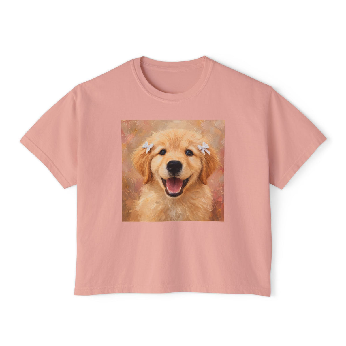 Peachy boxy t-shirt printed with a Golden Retriever puppy wearing hair ribbons and grinning