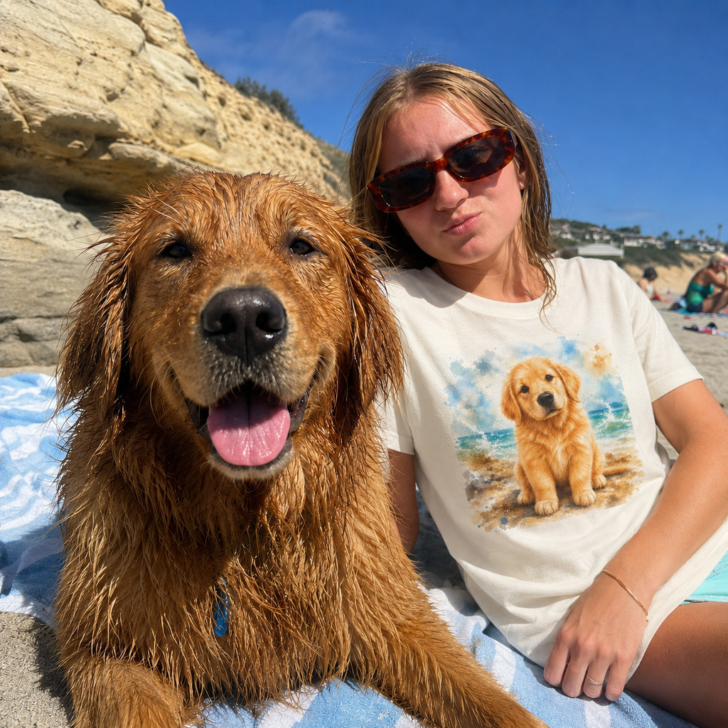 Natural t-shirt printed with a Golden Retriever puppy sitting on the shore among soft watercolor waves