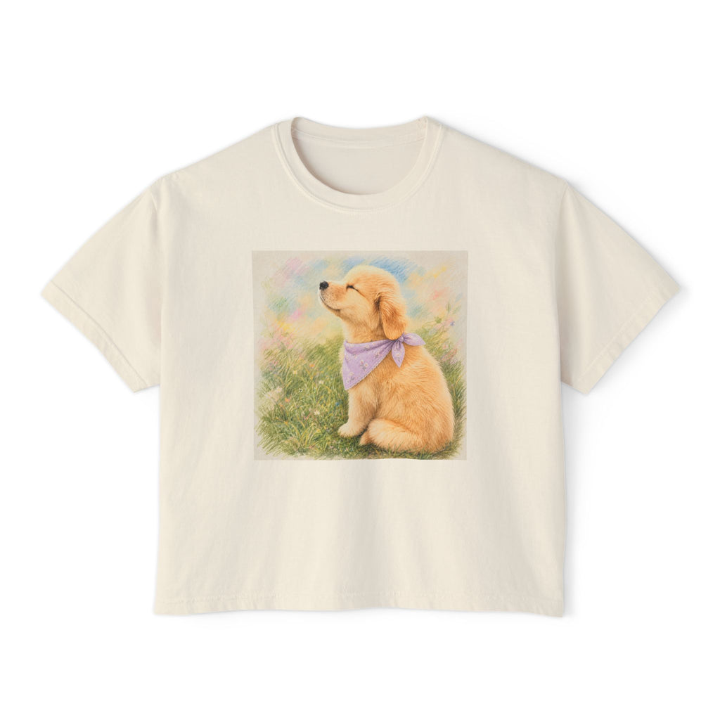 Ivory boxy t-shirt printed with a Golden Retriever puppy in a lavender bandana sitting in a grassland