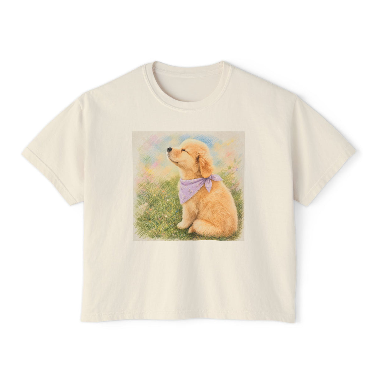 Ivory boxy t-shirt printed with a Golden Retriever puppy in a lavender bandana sitting in a grassland